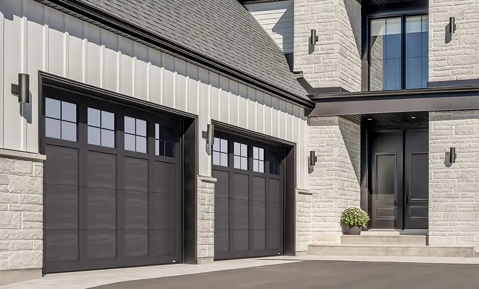 Maison transitionnelle Blanc et Noir avec pierre gris chaud, portes de garage Garaga en acier avec moulures PVC, design P-31, couleur Noir avec fenêtres